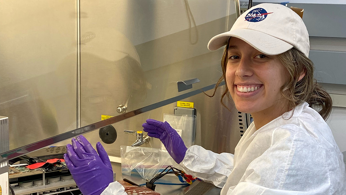 Fourth-year biomedical engineering student and Space Tango intern Nicole Frey with the CubeLab scheduled to fly to the International Space Station July 14 aboard a SpaceX Dragon capsule. UC San Diego researchers are sending brain organoids to space to study aging and disease, and Frey helped develop an agitation system to keep the cells healthy and functioning. Then she spent more than a week at Kennedy Space Center supporting the final checks of the entire system. (Photo Courtesy: Nicole Frey and Space Tan